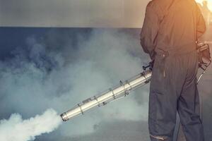 Man fogging to eliminate mosquito for prevent spread dengue fever photo