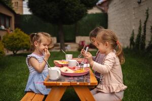Joyful meal time for children in a sunny backyard gathering photo