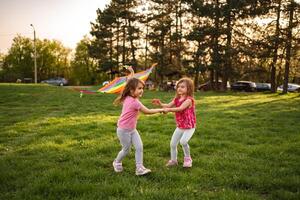 Joyful moments shared by two girls playing with a colorful kite photo