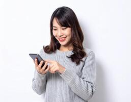 A smiling woman uses her smartphone while wearing a grey sweater photo
