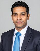 A professional portrait of a man in a dark suit and light blue tie photo