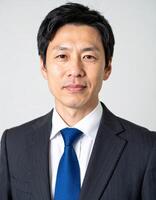 A professional portrait of a man in a dark suit and blue tie photo