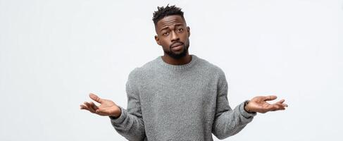 The man expressing confusion with a shrug in a casual sweater. photo