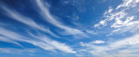 The breathtaking expanse of a clear blue sky with wispy clouds. photo