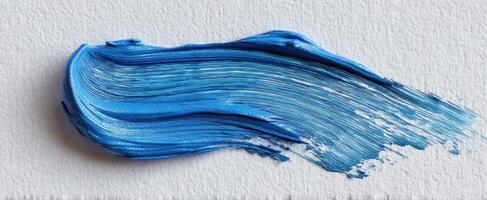 The vibrant blue paint stroke on textured canvas background. photo