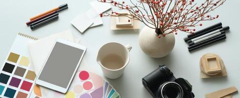 The workspace creatively arranged with artistic tools and a camera for inspiration. photo
