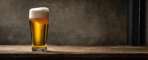 The refreshing glass of golden beer with creamy foam on a rustic table. photo
