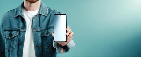 The smartphone held by a stylish young man against a blue background. photo