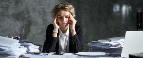 The overwhelmed businesswoman coping with stress in a chaotic office environment. photo