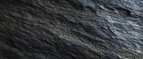 The textured slate rock surface showcasing its natural dark beauty and intricate patterns. photo