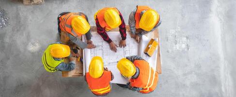 The construction team collaborating on blueprints for a new project. photo