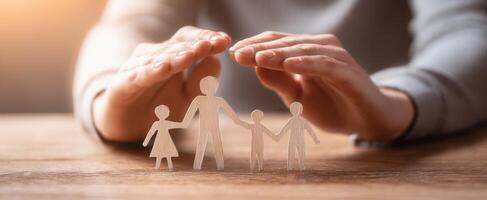 The family figures being protected by hands in a warm, caring environment. photo