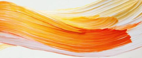 The flowing brushstrokes of vibrant orange and yellow paint on canvas. photo