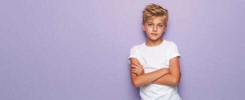 The confident boy posing with arms crossed against a purple background photo