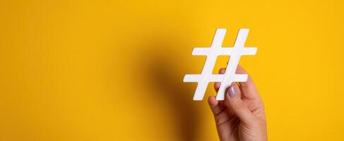 The Hand Holding a White Hashtag on a Bright Yellow Background photo