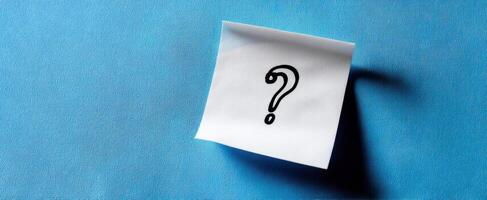 The Sticky Note with a Question Mark on a Blue Background photo