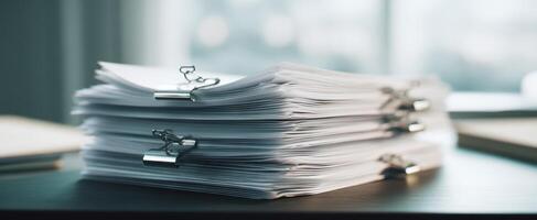 The organized stack of documents on a modern office desk. photo
