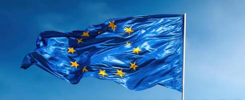The European Union flag waving gracefully against a clear blue sky. photo