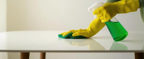 The cleaning process with a green spray and yellow-gloved hands. photo