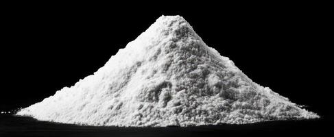 The mound of white salt on a dark background showcasing culinary versatility. photo