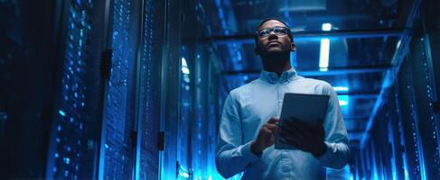 The professional man analyzing data in a modern server room environment. photo