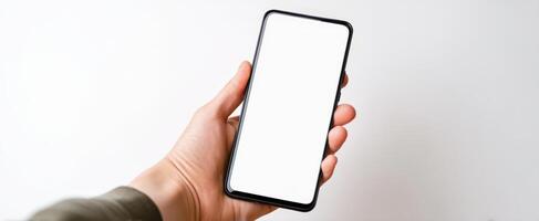 The smartphone held in a hand with a blank screen against a white background. photo