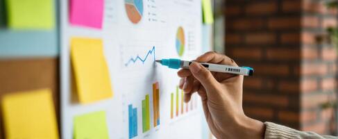 The hand analyzing graphs and charts on a business presentation board. photo
