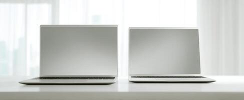 The sleek laptops positioned on a bright modern workspace with natural light. photo
