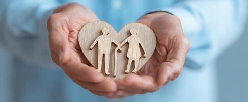 The wooden heart symbolizing love and partnership held in caring hands. photo