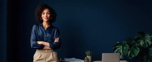 The confident woman standing in a modern office space with a laptop. photo