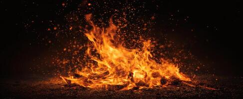 The captivating flames dancing in a dark environment with sparks flying. photo