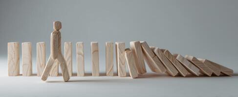 The wooden figure navigating a path among falling dominoes as a metaphor for challenges. photo