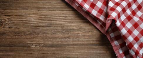The checkered tablecloth adding charm to a rustic wooden surface. photo