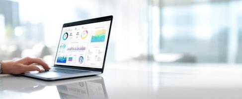 The sleek laptop displaying analytics and graphs in a modern workspace. photo