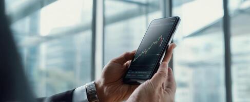 The smartphone displaying stock market trends and financial data in a business environment. photo
