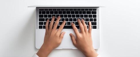 The hands typing on a laptop keyboard in a modern workspace setting. photo