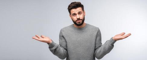 The man expressing confusion and uncertainty with a shrug and puzzled expression. photo