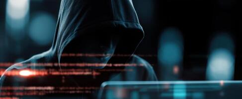 The mysterious hacker focused on a computer screen in a dark environment. photo