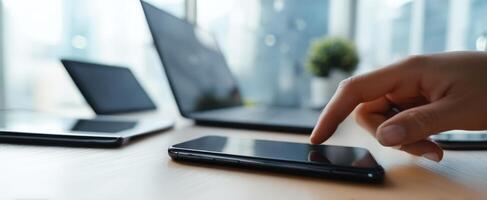 The smartphone being touched by a hand in a modern workspace setting. photo