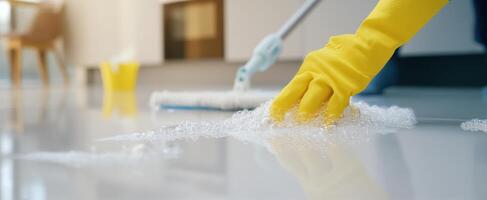 The cleaning process with soap bubbles and yellow gloves on a shiny floor. photo