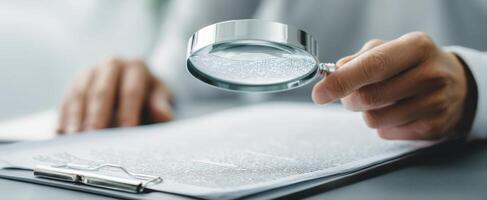 The magnifying glass highlighting details on important documents for analysis. photo