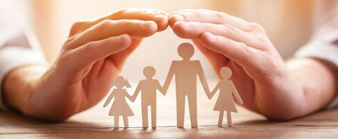 The hands providing protection to a paper family symbolizing love and unity photo