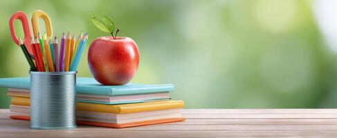 The colorful stationery arrangement with an apple on top of notebooks. photo