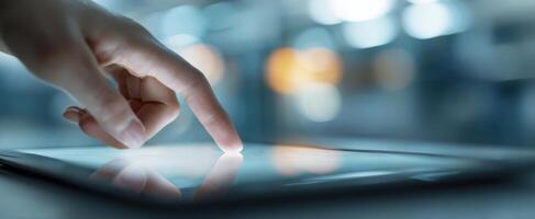The hand interacting with a touchscreen tablet in a modern workspace environment. photo
