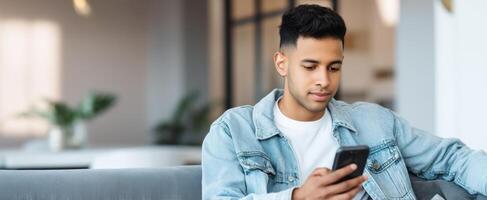 The young man enjoying his smartphone while sitting in a stylish interior. photo