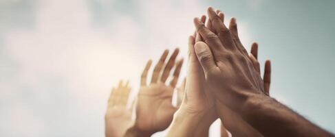 The Hands Raised Together in Unity Against a Bright Sky photo