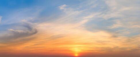 The captivating sunset illuminating the vast sky filled with soft clouds. photo