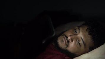 Man struggling with sleeplessness using smartphone in bed at night video