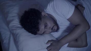 Man struggling with sleep and insomnia in bed video