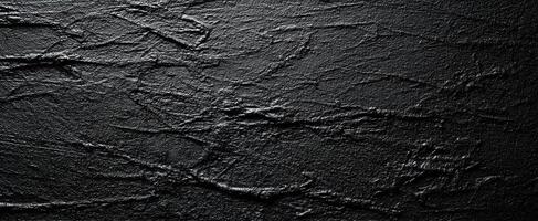 The textured black surface with intricate patterns and minimalistic design. photo